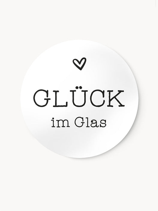 Runder, selbstklebender Aufkleber mit der Beschriftung "Glück im Glas" und einem Herz in schwarz, weißem Design.